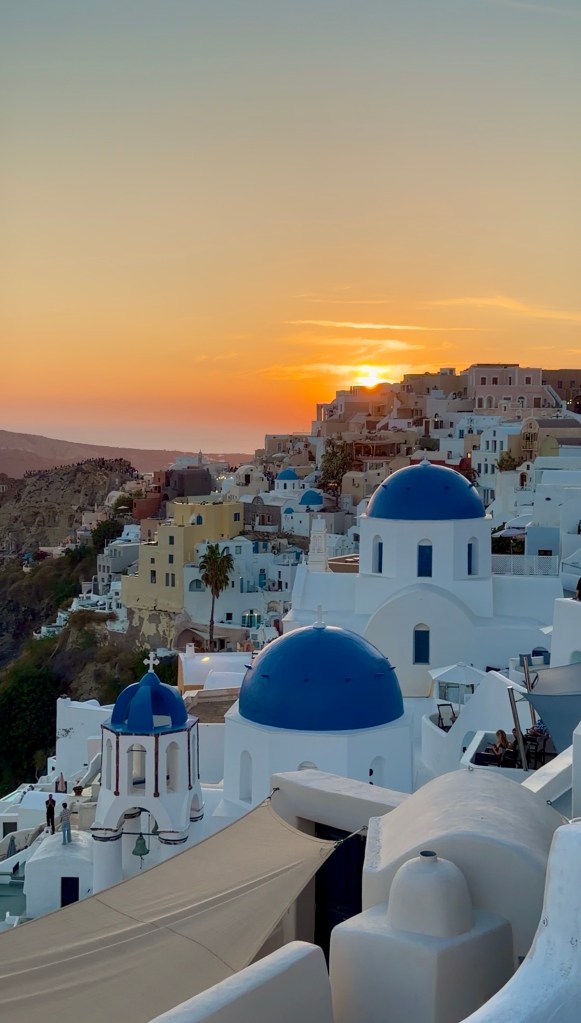 Iconic blue domes at sunset in Oia, Santorini, Greece